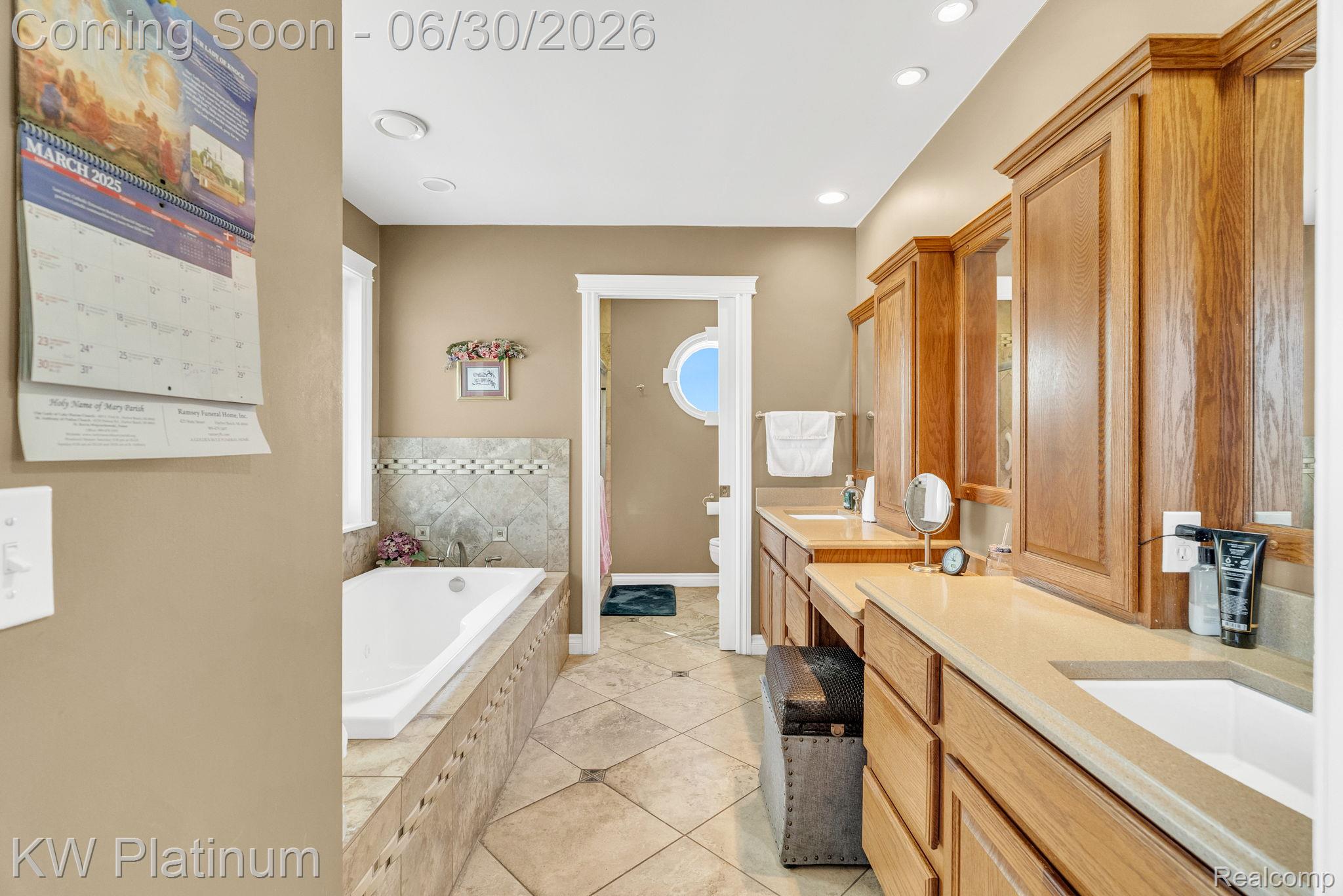 2235 South Lake Shore Road Harbor Beach, MI 48441 - Photo 33 of 99 Spacious bathroom featuring a built-in soaking tub with tiled surround, dual vanity with wood cabinetry, integrated sinks, and neutral countertop