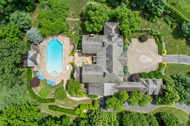 an aerial view of a house with a swimming pool and tennis court