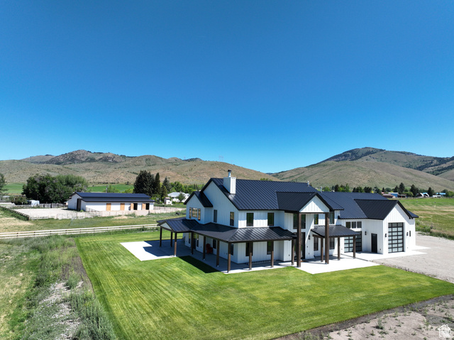 100 Whit Lane Georgetown, ID 83239 - Photo 1 of 76 Back of property with a mountain view, a lawn, a garage, a chimney, and a metal roof