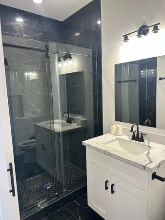 a bathroom with a granite countertop sink and a mirror