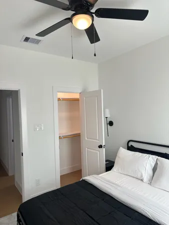 a bedroom with a bed and a ceiling fan