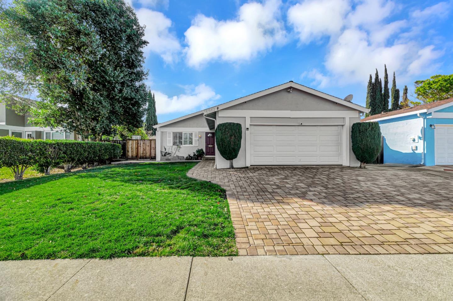 a view of a house with a yard and large tree
