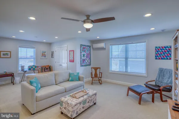 a living room with furniture a ceiling fan and a rug