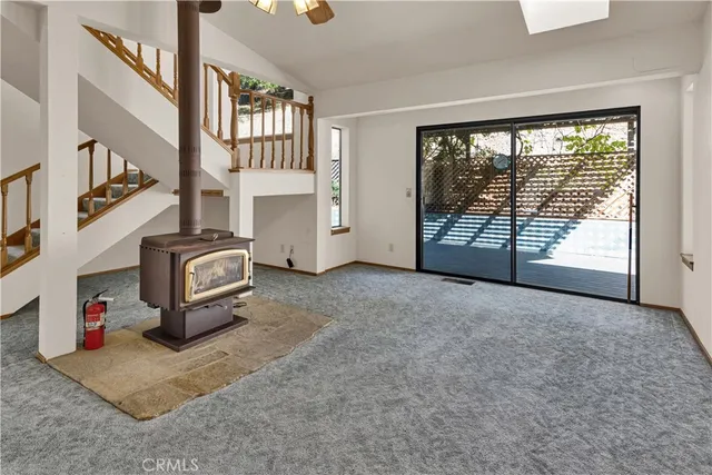 a view of an empty room with a fireplace and a window