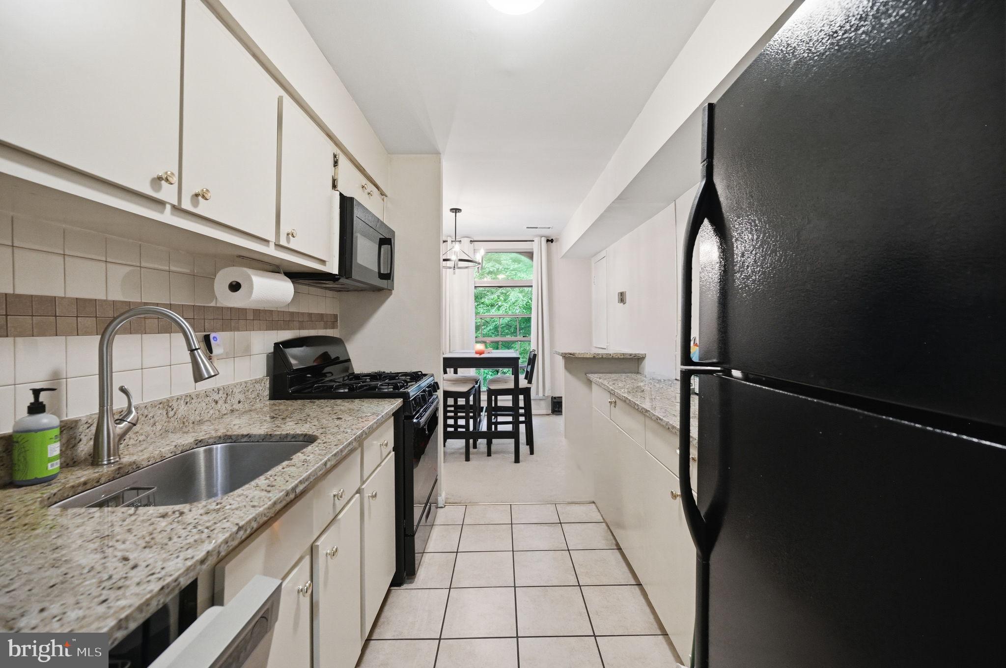3366 Woodburn Road, Unit 23 Annandale, VA 22003 - Photo 3 of 16 a kitchen with stainless steel appliances granite countertop a sink a stove and refrigerator