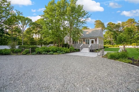 a view of a house with a yard and potted plants