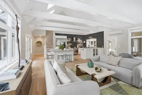 a bedroom with a large bed couches and a flat screen tv