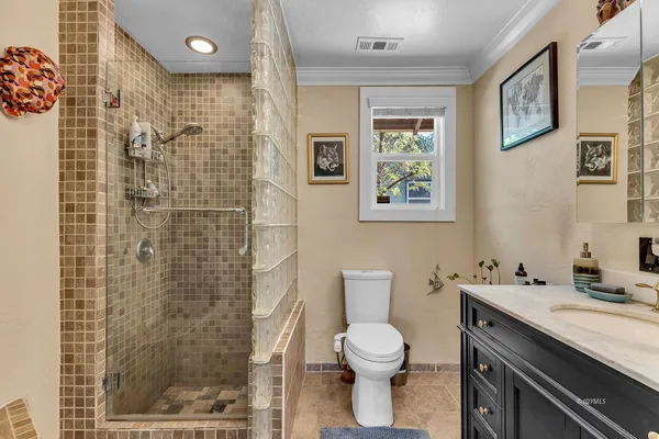 a bathroom with a granite countertop toilet sink and a shower