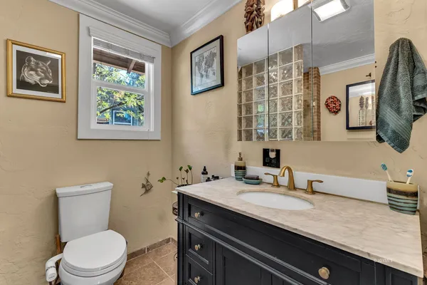 a bathroom with a granite countertop toilet sink and mirror