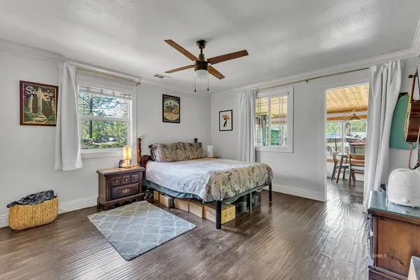 a spacious bedroom with a bed and wooden floor