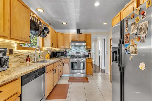 a kitchen with stainless steel appliances granite countertop a refrigerator and a sink