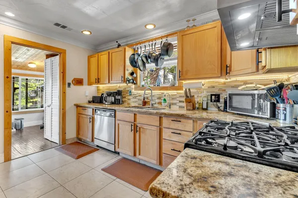 a kitchen with stainless steel appliances a stove a sink and a microwave