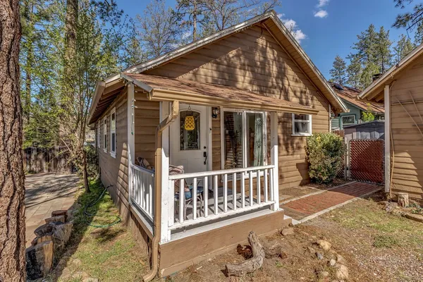 a view of a house with a small yard and wooden fence