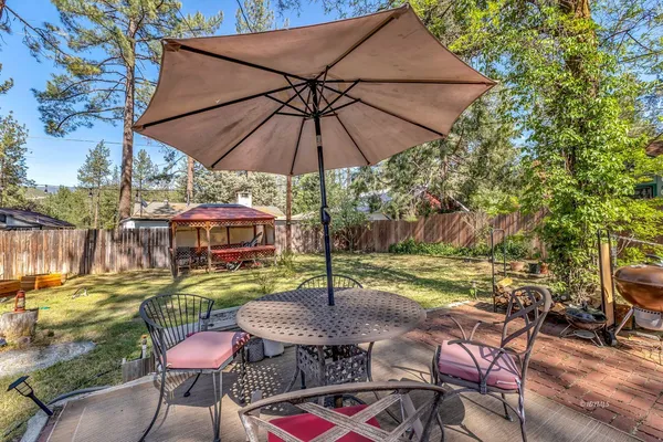 a patio with tables and chairs under an umbrella