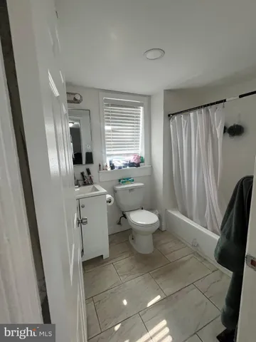 a bathroom with a sink toilet and window