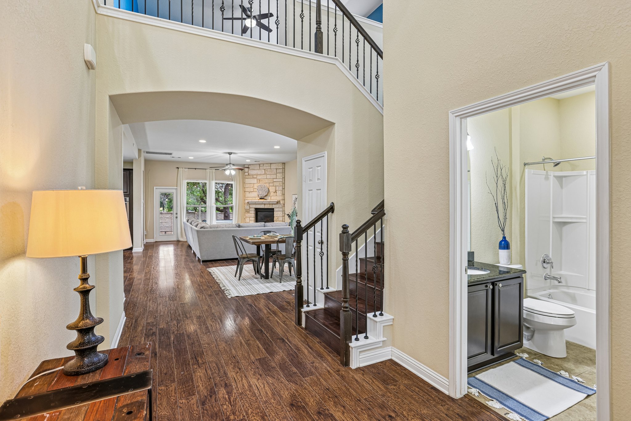 1924 Granite Springs Road Leander, TX 78641 - Photo 5 of 36 Rich hardwood floors welcome guests, leading past a conveniently located bath and toward the living area with a cozy fireplace.