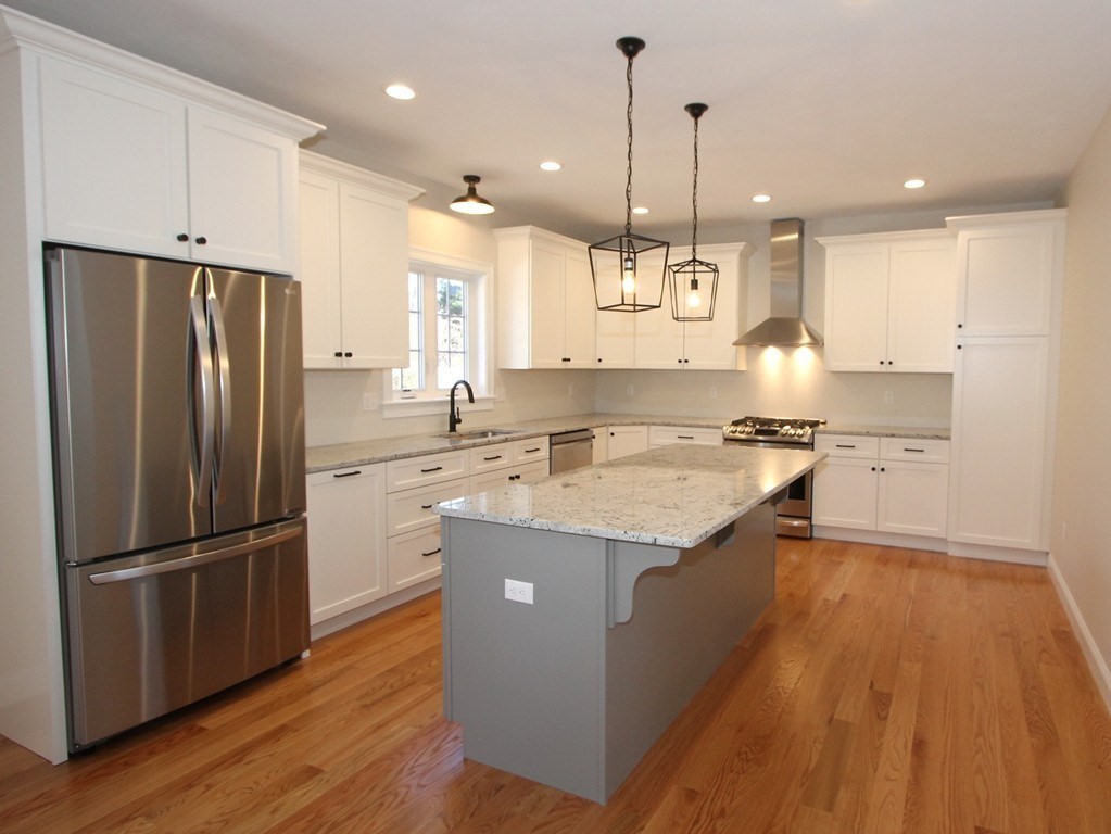 135 South S Road Holden, MA 01520 - Photo 10 of 25 a kitchen with stainless steel appliances granite countertop a refrigerator a sink dishwasher a stove and white cabinets with wooden floor