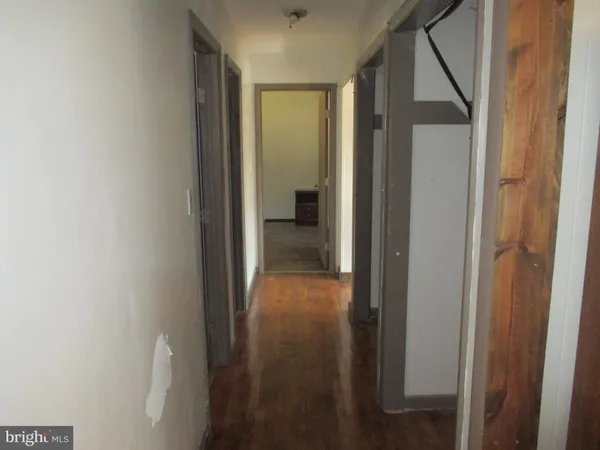 a view of a hallway with wooden floor and entryway