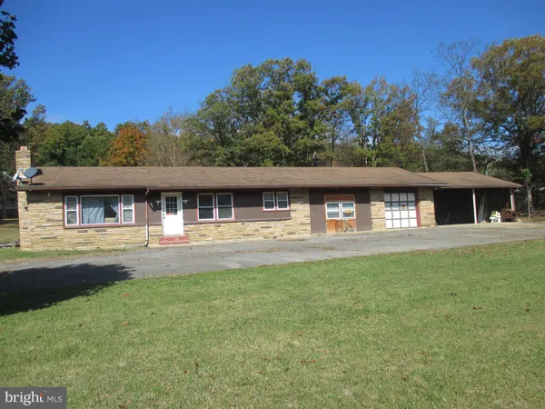 a front view of house with yard and trees in the background