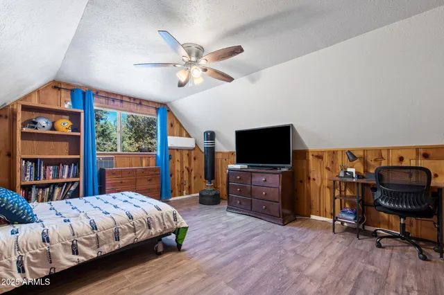 a bedroom with a bed and furniture with wooden floor
