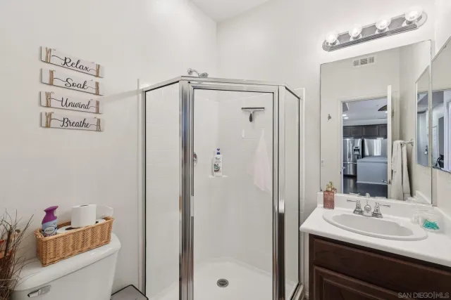 a bathroom with a sink vanity mirror and shower