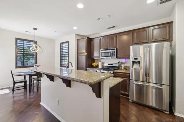 a kitchen with kitchen island a refrigerator stove microwave and cabinets