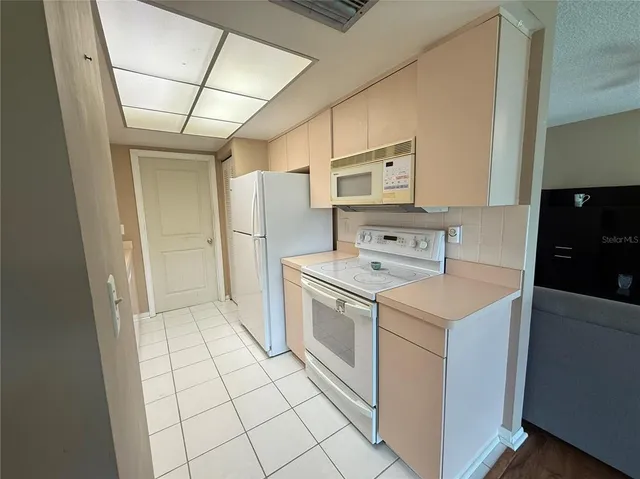 a kitchen with a sink a stove cabinets and a refrigerator