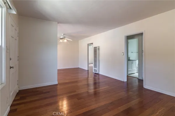 a view of an empty room with wooden floor