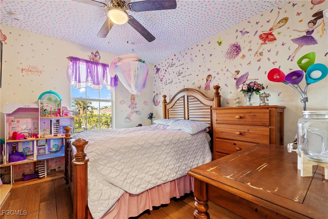 8657 Sumner Avenue Fort Myers, FL 33908 - Photo 21 of 29 a bedroom with a bed and wooden floor