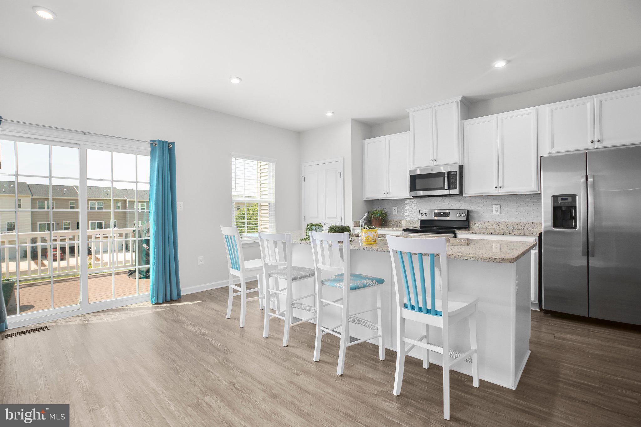 8410 Devries Lane Spotsylvania, VA 22553 - Photo 4 of 32 a kitchen with stainless steel appliances a dining table chairs refrigerator and cabinets