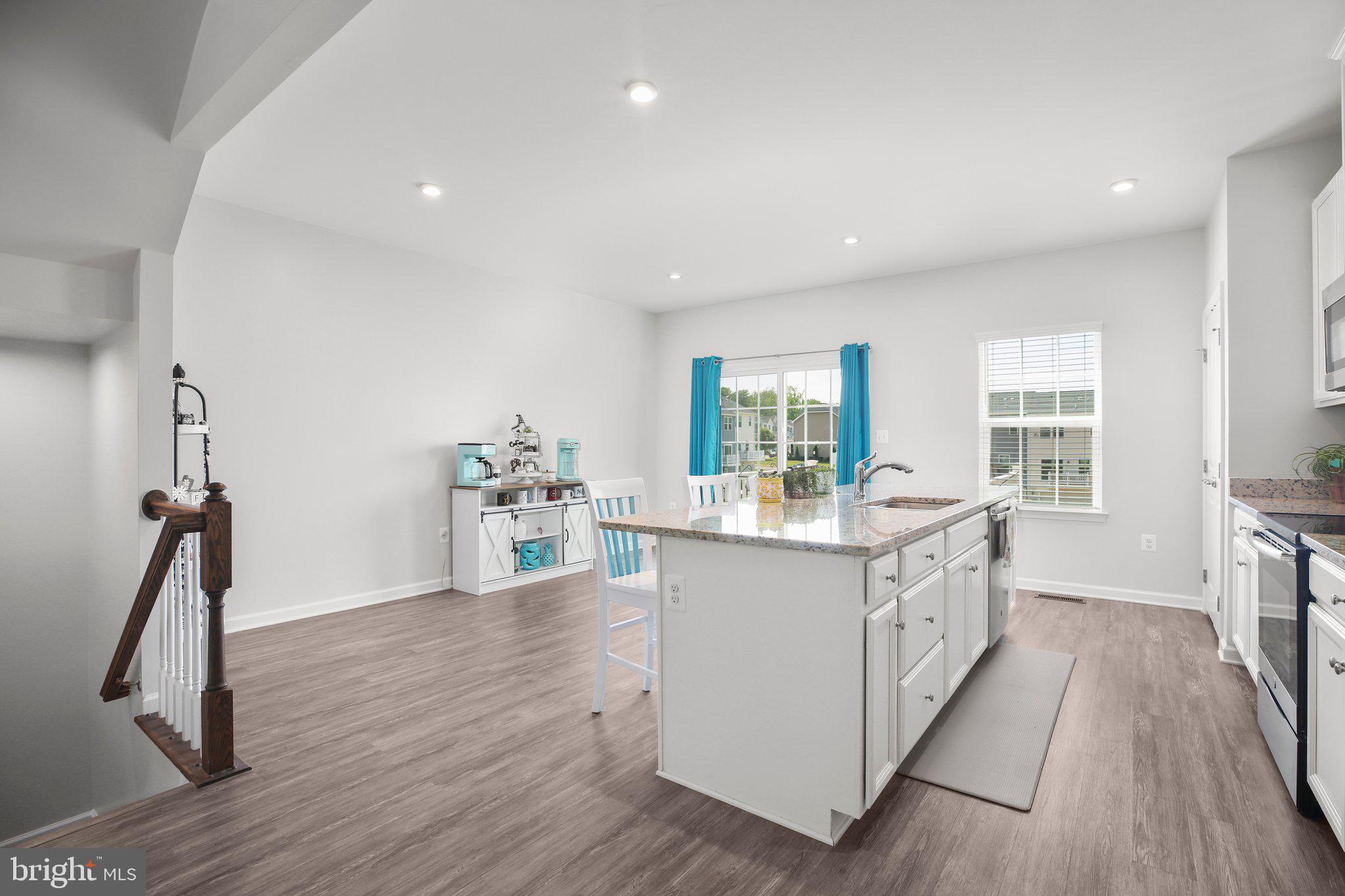 8410 Devries Lane Spotsylvania, VA 22553 - Photo 7 of 32 a kitchen with granite countertop a sink appliances wooden floor and a large window