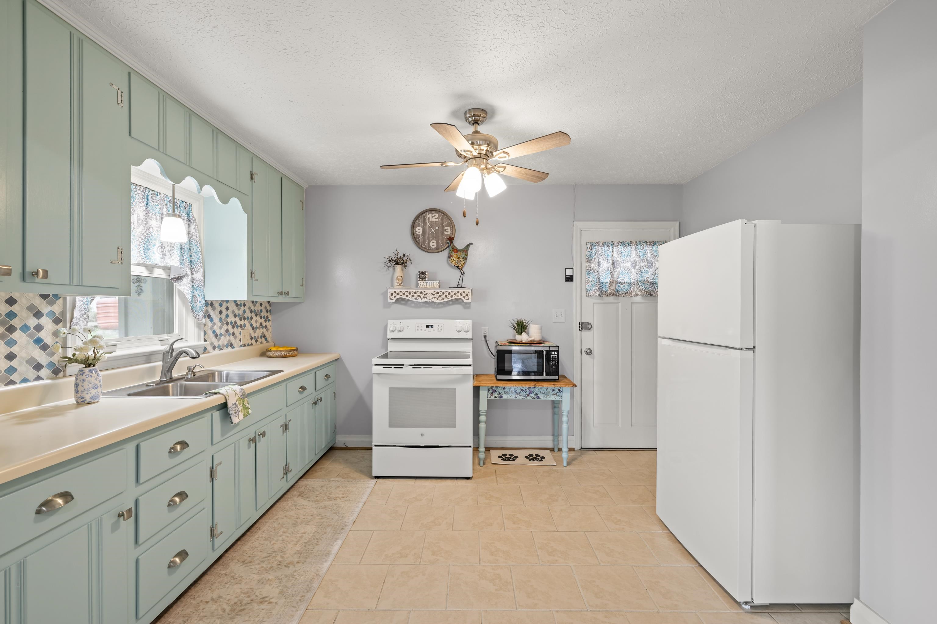 118 Stuart Avenue Stuarts Draft, VA 24477 - Photo 16 of 61 a kitchen with white cabinets and white appliances