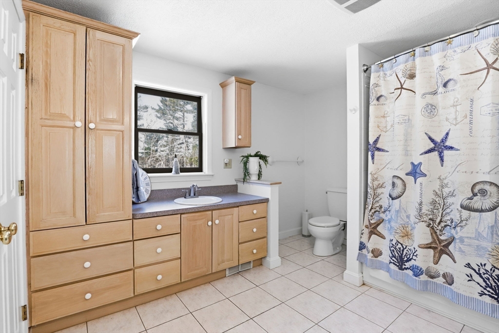 40 Fosdick Road Carver, MA 02330 - Photo 19 of 27 a bathroom with a granite countertop toilet a sink and a window