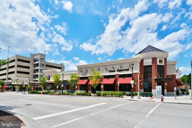 a group of people sitting on a street in front of building