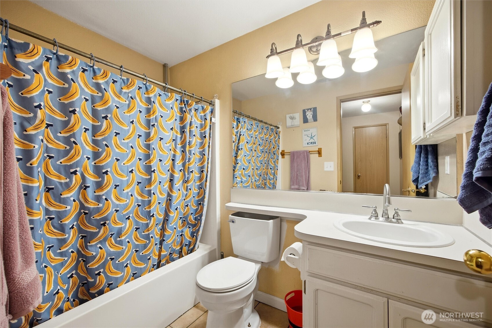 5008 Polo Lane Pasco, WA 99301 - Photo 22 of 26 a bathroom with a sink a toilet a mirror a lamp and shower curtain