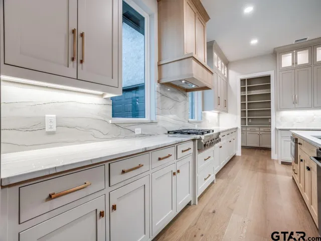 a large kitchen with stainless steel appliances and white cabinets