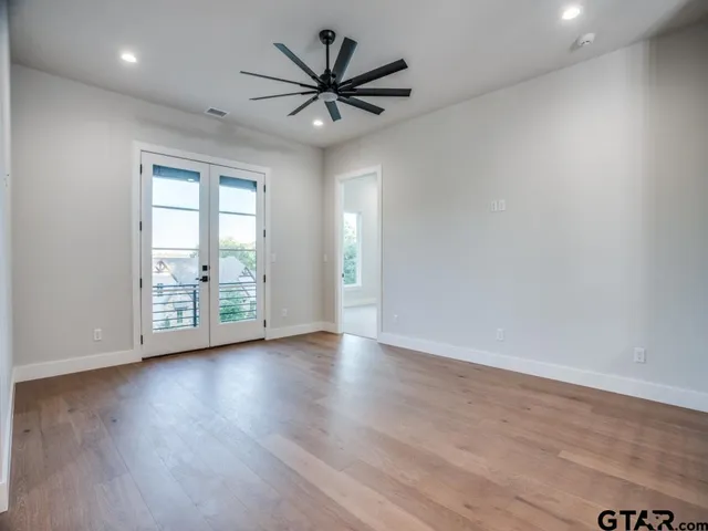 an empty room with wooden floor and windows