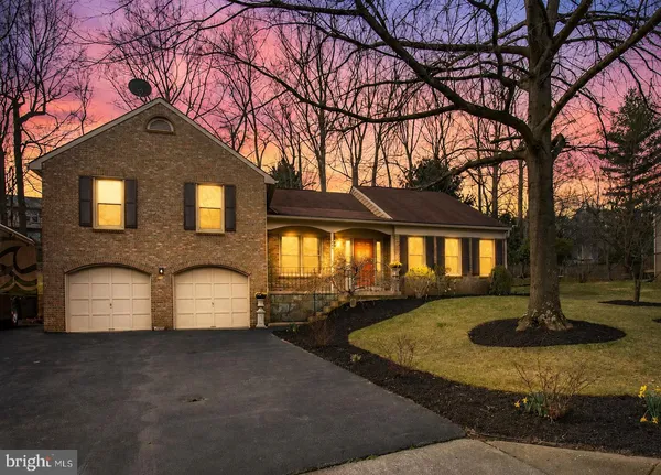 a front view of a house with a yard and tree