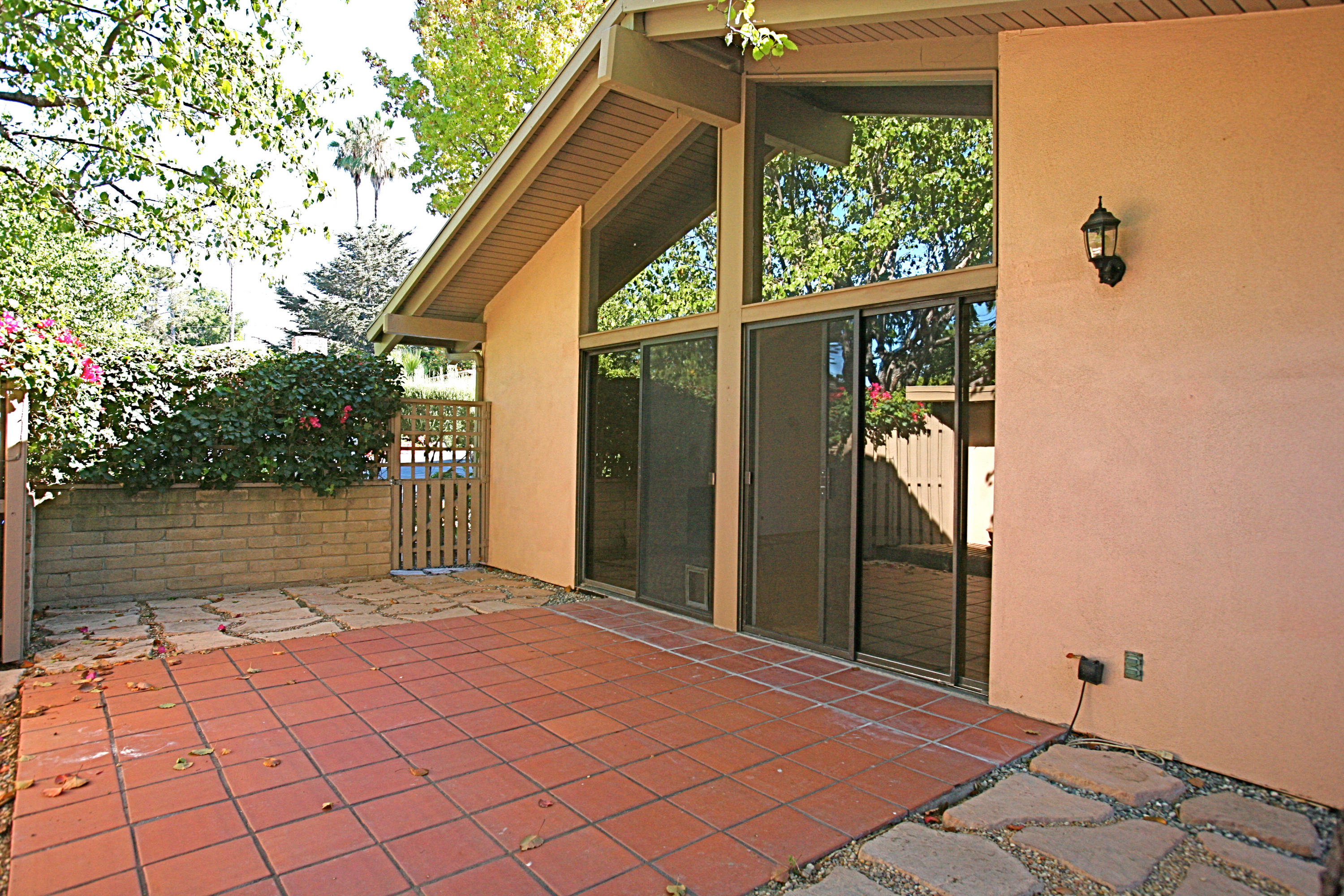 561 North La Cumbre Road Santa Barbara, CA 93110 - Photo 5 of 12 a backyard of a house with large trees and a wooden bench