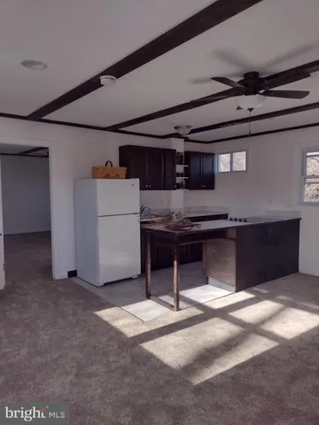 a view of kitchen with refrigerator and microwave