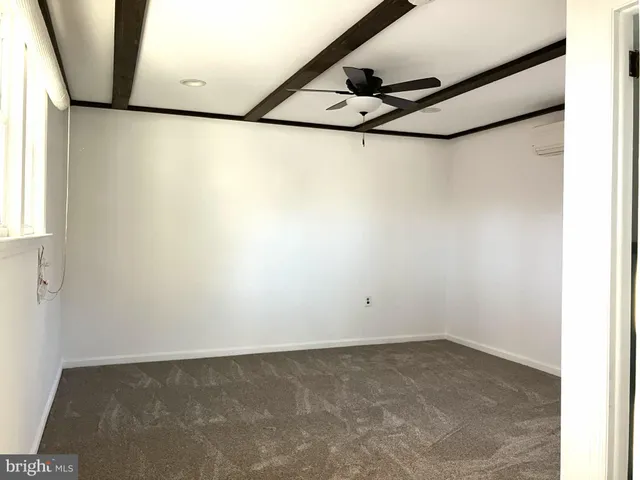 a view of a livingroom with wooden floor and a ceiling fan