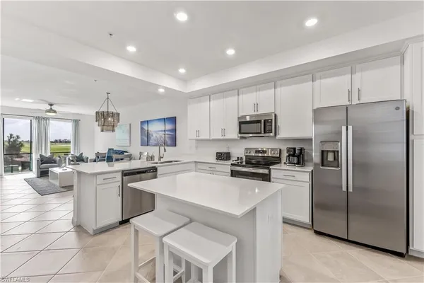 a kitchen with cabinets a sink stainless steel appliances and dining table