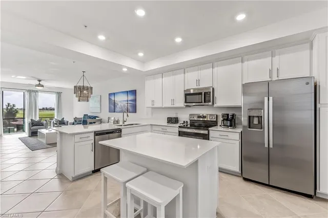 a kitchen with cabinets a sink stainless steel appliances and dining table