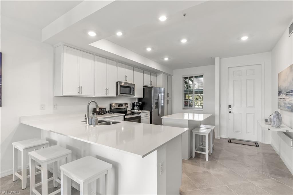 43977 Boardwalk Loop, Unit 2315 Babcock Ranch, FL 33982 - Photo 7 of 15 a kitchen with cabinets a sink stainless steel appliances and dining table