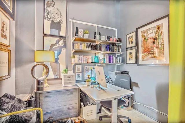 a view of a workspace with furniture and a window