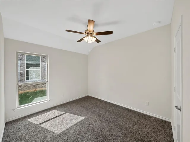 an empty room with chandelier fan