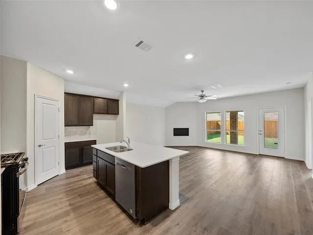 a kitchen with stainless steel appliances granite countertop a sink stove and refrigerator