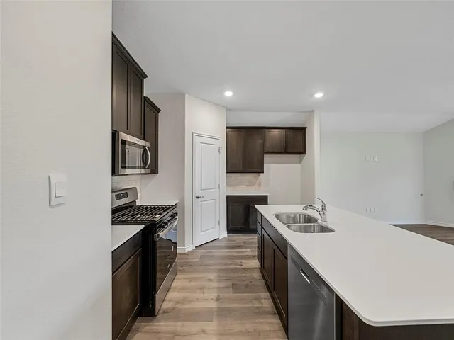 a kitchen with stainless steel appliances a sink stove and refrigerator