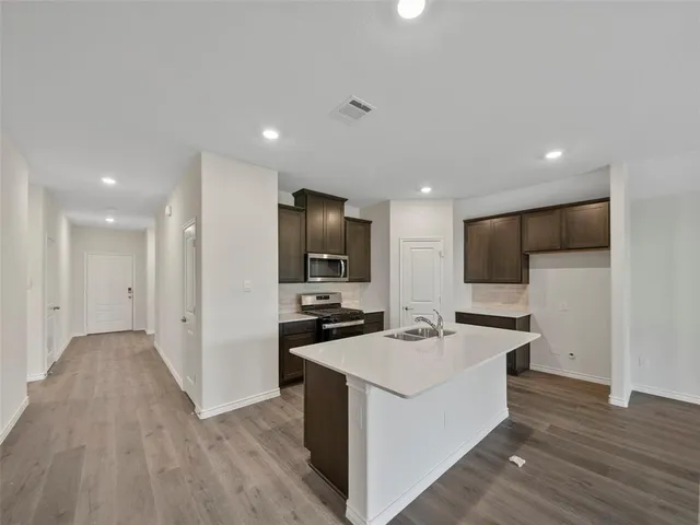a kitchen with stainless steel appliances a refrigerator and a stove top oven