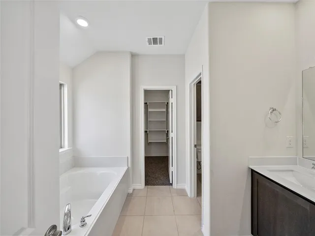 a bathroom with a tub shower and a sink